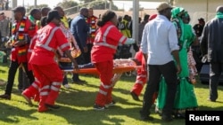 Des secouristes accourent après l'explosion d'une grenade d'un meeting du président Emmerson Mnangagwa à Bulawayo, au Zimbabwe, le 23 juin 2018.