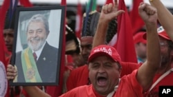 A supporter holds a photo of Brazil's jailed former president, Luiz Inacio Lula da Silva, as he takes part in the Free Lula March, in Brasilia, Aug. 15 2018. 