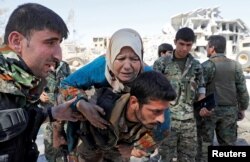 Fighters of Syrian Democratic Forces (SDF) evacuate a civilian in Raqqa, Syria, Oct. 17, 2017.