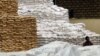 FILE - A worker takes a lunch break while sitting amongst the stack of food aid, at the U.N. World Food Program warehouse in Mombasa, Kenya, Dec. 3, 2008. 