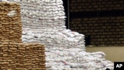 FILE - A worker takes a lunch break while sitting amongst the stack of food aid, at the U.N. World Food Program warehouse in Mombasa, Kenya, Dec. 3, 2008. 