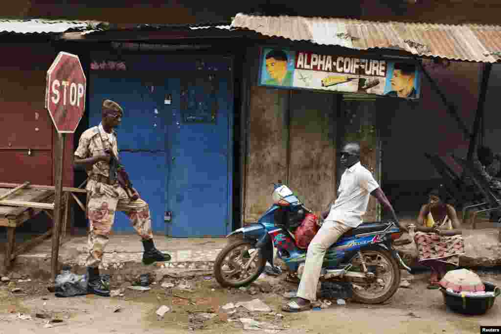 A Malian national guardsman (L) takes up a post along a street outside the Grand Mosque before Eid al-Fitr prayers in Bamako, Mali, August 8, 2013.&nbsp;