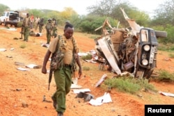 A Kenyan security person walks past a police vehicle damaged by a blast killing Kenyan police officers at the Garissa county, eastern Kenya, May 24, 2017.