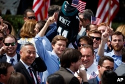 An Philadelphia Eagles fan carries the jersey of quarterback Carson Wentz during a "celebration of the American flag" event at the White House in Washington, June 5, 2018.