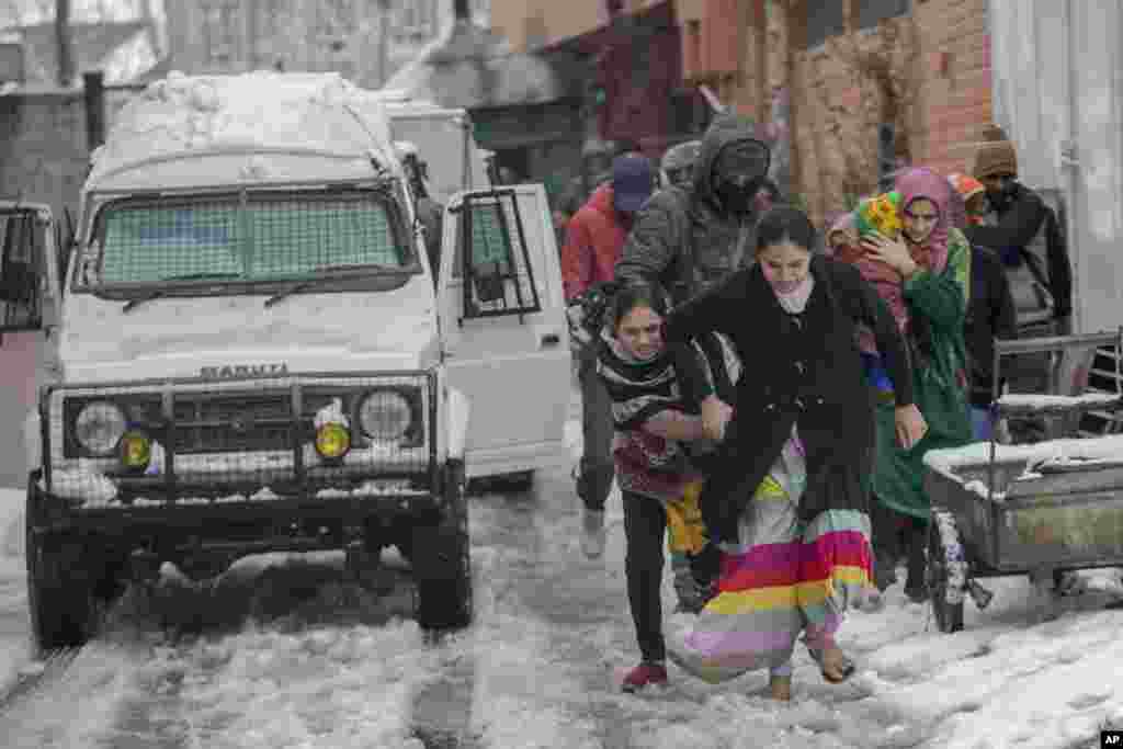 Family members of Indian paramilitary personnel living near the site of a gun battle run towards waiting vehicles in Srinagar, Indian-controlled Kashmir.