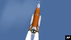 NASA image shows an artist's concept of the launch of the Space Launch System rocket and Orion capsule. On Feb. 24, 2017, NASA said it is weighing the risk of adding astronauts to the first flight of its new megarocket.