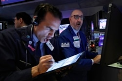 Trader Gregory Rowe, left, and specialist Peter Giacchi work on the floor of the New York Stock Exchange, Thursday, March 12, 2020. Stocks are sharply lower after resuming trading as traders fear that not enough is being done to help the economy.