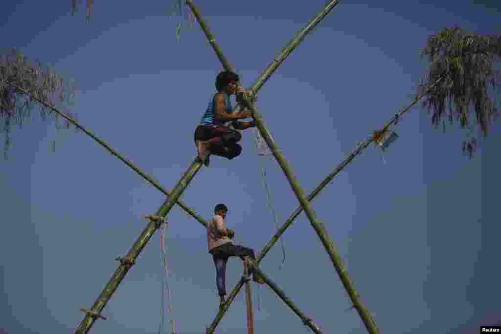 Men build a traditional swing using bamboos during the Dashain, Hinduism's biggest religious festival, in Kathmandu, Nepal.