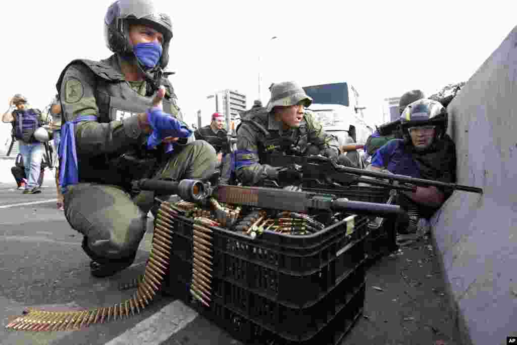 Venezuelan soldiers join opposition leader Juan Guaido in his campaign to oust the government of Nicolas Maduro, on an overpass outside La Carlota military airbase as they confront troops who remain loyal to Maduro, in Caracas, Venezuela.