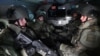 FILE - Russian officials are sitting in a military vehicle as they take part in tactical exercises of an assault technique unit at a training ground in Kamensk-Shakhtinsky in the Rostov region, Russia, January 17, 2022. 