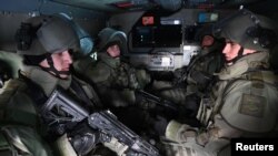 FILE - Russian service members sit inside a military vehicle as they take part in tactical exercises of an assault engineering unit at a training ground in Kamensk-Shakhtinsky in the Rostov region, Russia, Jan. 17, 2022. 