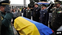 Commanders of the Police and Armed Forces of Colombia salute by the coffin of lieutenant colonel Alfredo Ruiz next to his wife Daissy Esperanza (2-L) during his funeral in Bogota, Colombia, on June 14, 2015. 