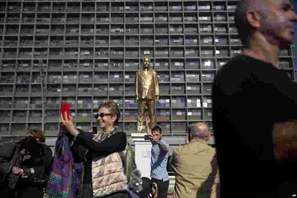 People look at a statue of Israeli Prime Minister Benjamin Netanyahu at a central square in Tel Aviv. Israeli artist Itay Zalait placed the 4.5-meter (15-foot) statue is to test freedom of expression, with a reference to the biblical golden calf, and a dig at some Israelis’ idolatry of the longtime leader. City Hall said it was placed without a permit and has ordered it removed. 