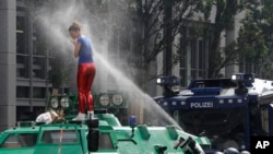 A woman is pepper-sprayed by police after she climbed an armored police vehicle on the first day of the G-20 summit in Hamburg, northern Germany, July 7, 2017.