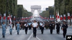 Japanese troops parade on the Champs Elysees avenue during a rehearsal for Bastille Day, early Wednesday, July 11, 2018, in Paris. Japanese and Singapore soldiers will take part in the annual Bastille Day next Saturday. 