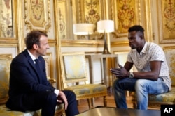 French President Emmanuel Macron, left, meets with Mamoudou Gassama, 22, from Mali, at the presidential Elysee Palace in Paris, Monday, May, 28, 2018.