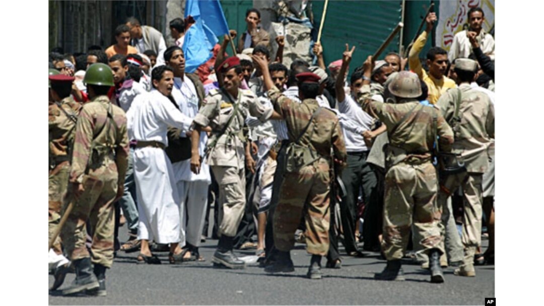 Soldiers hold back supporters of Yemen's President Ali Abdullah Saleh during clashes with anti-government protesters in the southern city of Taiz, Apr 22 2011