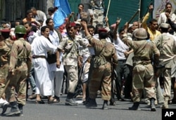 Soldiers hold back supporters of Yemen's President Ali Abdullah Saleh during clashes with anti-government protesters in the southern city of Taiz, Apr 22 2011