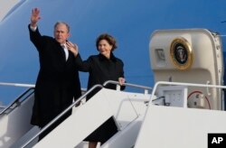 El expresidente George W. Bush saluda junto con a esposa, Laura Bush, desde el avión en el que acompaña el cuerpo de su padre el expresidente George H.W. Bush tras ceremonias de honor en Washington, de regreso a Texas para su último servicio funeral y entierro. Dic. 5 de 2018.