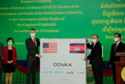 Cambodian Health Minister Mam Bunheng, right, receives the first batch of donated one million doses of the Johnson & Johnson Covid-19 vaccines from U.S. Embassy Deputy Chief of Mission Ben Wohlauer at a handover ceremony at Phnom Penh International Airport, July 30, 2021. (Hean Socheata/VOA Khmer)