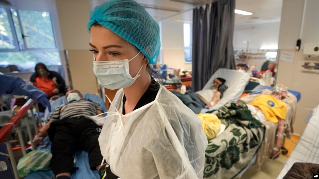 FILE - A member of the medical staff walks in a crowded COVID-19 isolation room at the University Emergency Hospital in Bucharest, Romania, Oct. 22, 2021. (AP Photo/Vadim Ghirda, File)