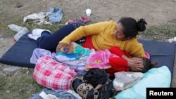 Honduran migrants Dirian Cintura and his daughter take a break from traveling in the caravan, on the journey to the U.S., at a sports field in Matias Romero, Oaxaca, Mexico, Apr. 4, 2018.