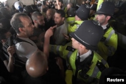 Police officers confront demonstrators inside Kensington Town Hall, during a protest following the fire that destroyed The Grenfell Tower block, in north Kensington, West London, Britain, June 16, 2017.