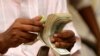 A Somali man counts his money at a Dahabshiil money transfer office in "Kilometer Five" street of Soobe village, southern Mogadishu, May 8, 2013.