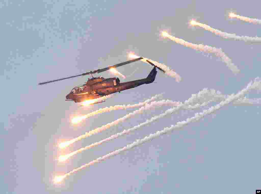 An AH-1W attack helicopter launches flares during Han Kuang military exercises in Penghu county, Taiwan, April 17, 2013.