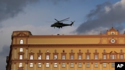 FILE - A Russian military Mi-35 helicopter takes off from the building of Russia's Federal Security Service, the successor agency of the Soviet-era KGB, in Lubyanskaya Square in Moscow, Russia, Feb. 26, 2016.