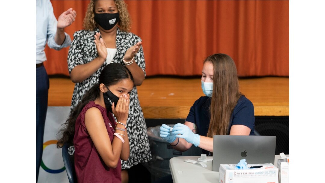 Ariel Quero (16, kiri), siswa di SMA Lehman, disuntik vaksin Pfizer COVID-19 oleh Katrina Taormina (kanan), di New York, 27 Juli 2021.