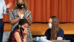 뉴욕의 고등학생이 교사들의 박수를 받으며 코로나 백신을 맞고 있다. (자료사진)