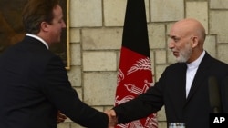 Afghan President Hamid Karzai, right, shakes hands with British Prime Minister David Cameron during a press conference at the presidential palace in Kabul, Afghanistan, June 29, 2013.