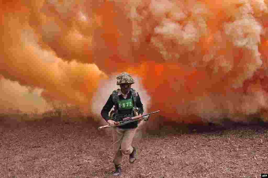 An Indian Border Security Force (BSF) commando runs from thick smoke during an excercise at the Kharkan Training Camp at Hoshiarpur, around 60 kms from Jalandhar.