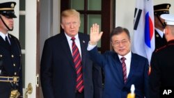 문재인 한국 대통령이 지난 5월 백악관에서 트럼프 미국 대통령과 만난 후 기자들을 향해 손을 흔들어 보이고 있다. 