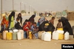 Women and children gather to collect water from a tap at a camp for internally displaced persons (IDPs) in al-Mazraq in the northwestern Yemeni province of Hajja, May 20, 2013.