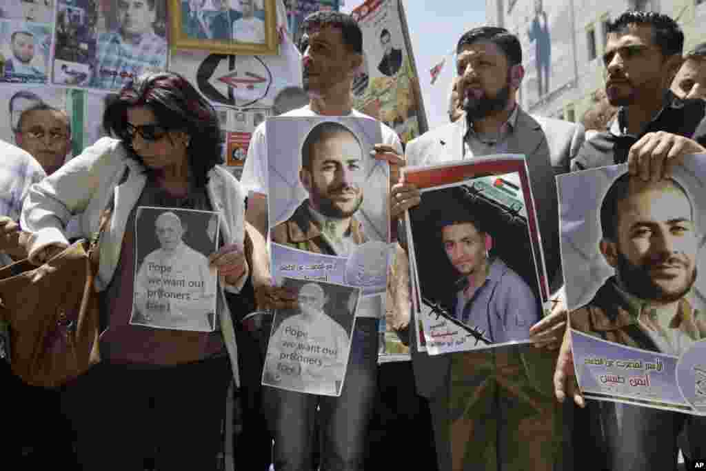 Palestinians hold pictures of Pope Francis and Palestinian prisoners during a demonstration to call for the release of prisoners from Israeli jails and to support prisoners who have been on hunger strike, in the West Bank town of Nablus.