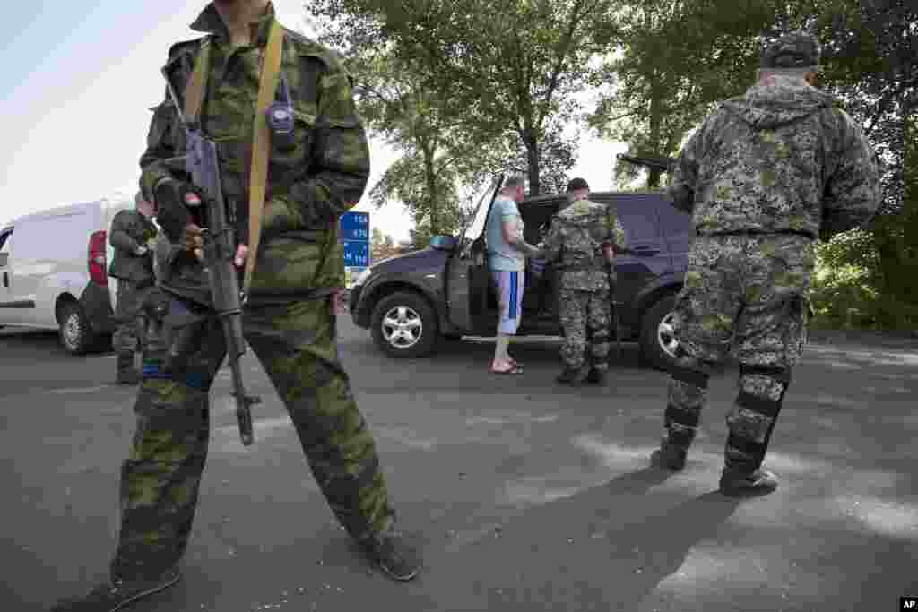 Militan pro-Rusia menjaga sebuah pos pemeriksaan yang menghalangi sebuah jalan layang besar di luar kota Slovyansk, Ukraina timur (19/5). (AP/Alexander Zemlianichenko)