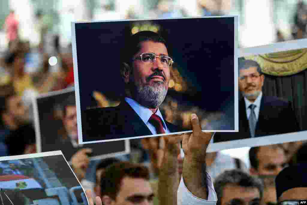 People hold picture of Egyptian President Mohamed Morsi during a symbolic funeral cerenomy on at Fatih mosque in Istanbul, Turkey. Thousands joined in prayer in Istanbul for former Egyptian president Mohamed Morsi who died the previous day after collapsing during a trial hearing in a Cairo court.