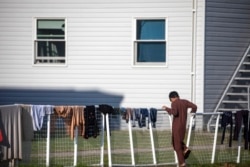 Seorang pengungsi Afghanistan berdiri di luar perumahan sementara di pangkalan Angkatan Darat AS Fort McCoy di Fort McCoy, Wisconsin., 30 September 2021.