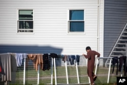 FILE - An Afghan refugee stands outside temporary housing at the Fort McCoy U.S. Army base in Fort McCoy, Wis., Sept. 30, 2021.