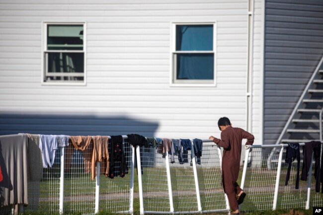 FILE - An Afghan refugee stands outside temporary housing at the Fort McCoy U.S. Army base in Fort McCoy, Wis., Sept. 30, 2021.