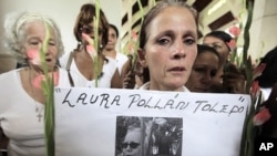 A member of the Ladies in White holds a picture of leader Laura Pollan, inside a church after a march in homage of Laura Pollan, along the main avenue of the upscale Havana district of Miramar in Havana, October 16, 2011.