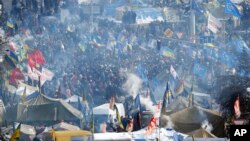 Smoke from cooking fires rise over the tent camp of pro-European Union activists on Independence Square in Kyiv, Ukraine, Sunday Jan. 26, 2014.