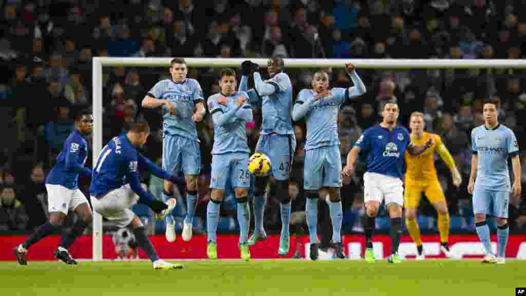Les joueurs de Manchester City, y compris Yaya Touré (C) sautent pour bloquer un coup franc tiré Kevin Mirallas d&#39;Everton, seconde à gauche, lors du match de football anglais de Premier League entre Manchester City et Everton à l&#39;Etihad Stadium, Manchester, en Angleterre, le 6 décembre 2014 .