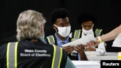 FILE - Poll workers prepare absentee ballots for shipment at the Wake County Board of Elections on the first day that the state started mailing them out, in Raleigh, North Carolina, U.S. September 4, 2020. (REUTERS/Jonathan Drake/File Photo)