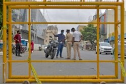 Polisi menghentikan pengendara motor di sebuah pos pemeriksaan selama pemberlakuan kembali karantina di tengah pandemi Covid-19 di Bangalore, India, 15 Juli 2020.
