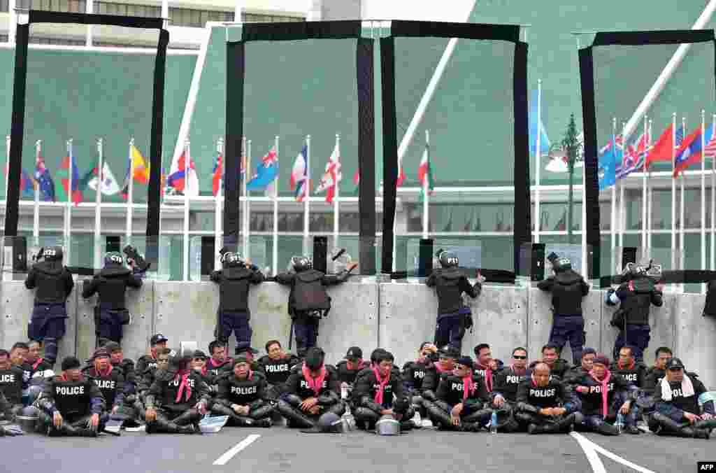 Thai riot policemen rest during an anti-government rally against an amnesty bill near Government House in Bangkok. 