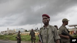 Soldiers allied with Alassane Ouattara stand in a road in the Youpougon neighborhood of Abidjan, Ivory Coast, Sunday, April 10, 2011