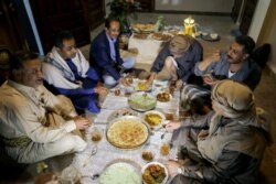 Penyanyi Yaman, Fouad al-Kebsi dan saudaranya Akram, duduk bersama para tamu untuk buka puasa bersama di rumah keluarga mereka saat bulan suci Ramadan di Sanaa, Yaman 19 April 2021. (REUTERS / Khaled Abdullah)